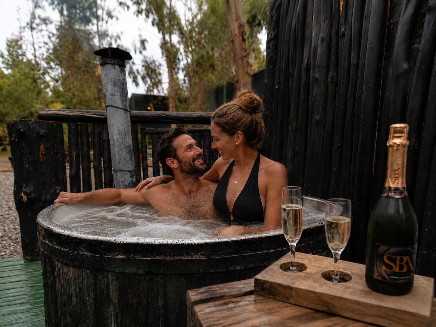 Pareja disfrutando una tina de madera de Bosques de San José